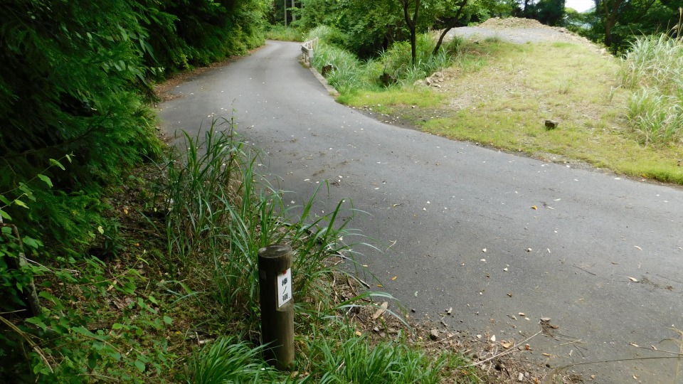 林道へおりる。正面、道路下に方角案内板がある。